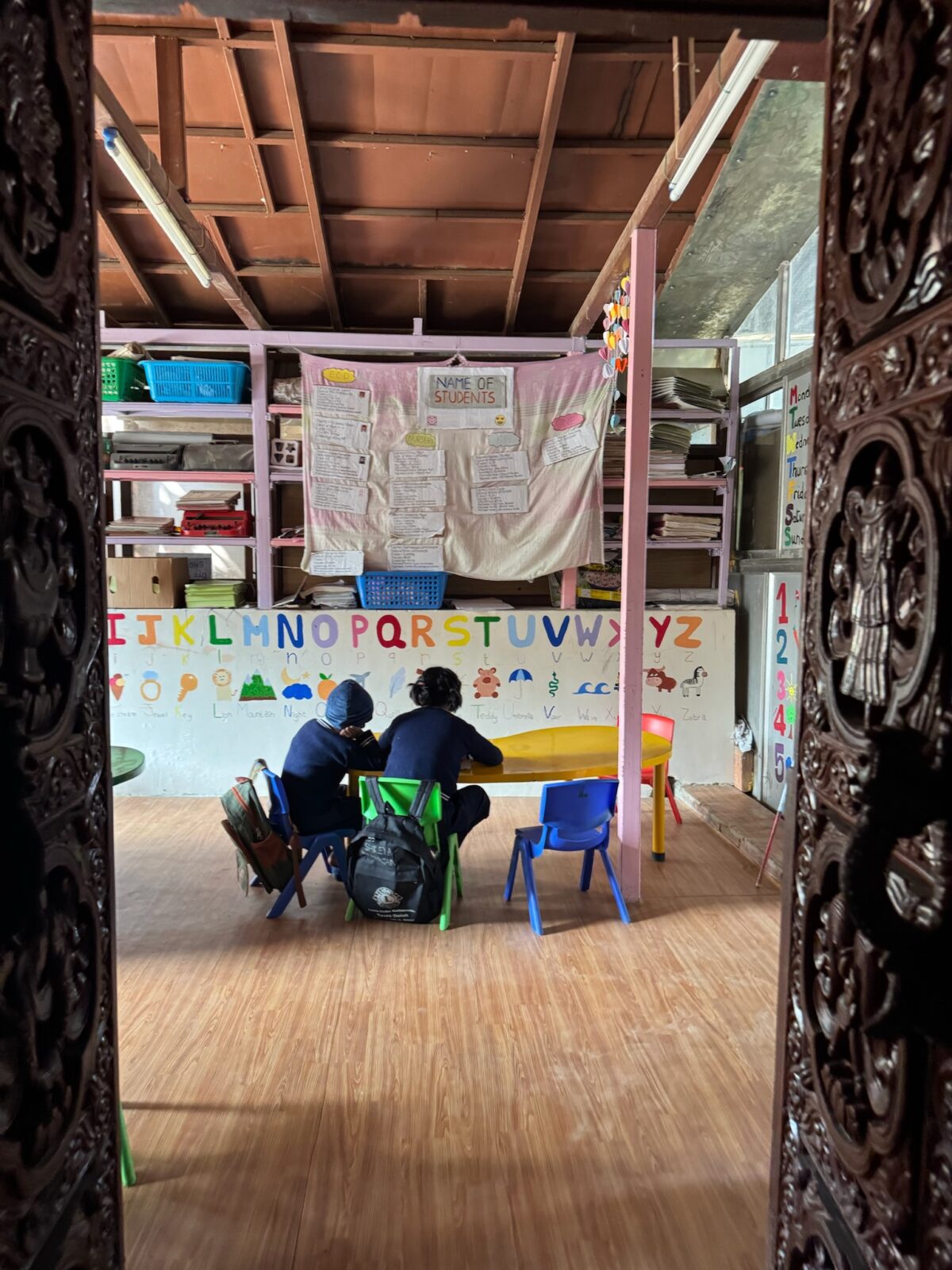 image of two children in a classroom in Nepal working on school work
