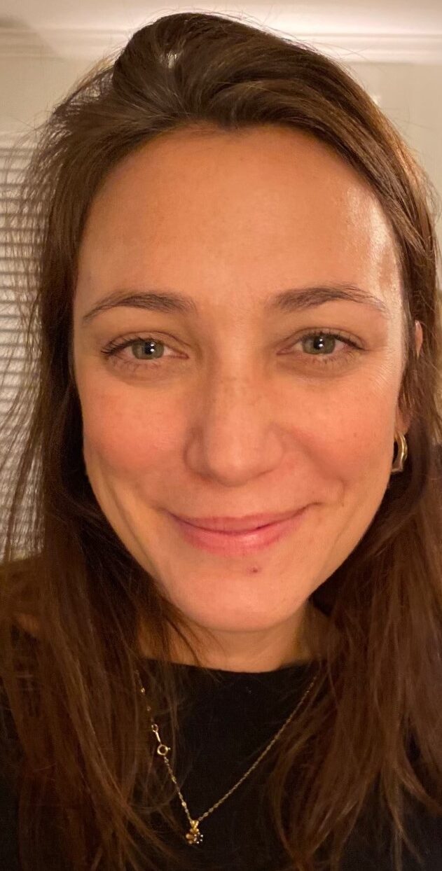 Woman with long brown hair smiles.