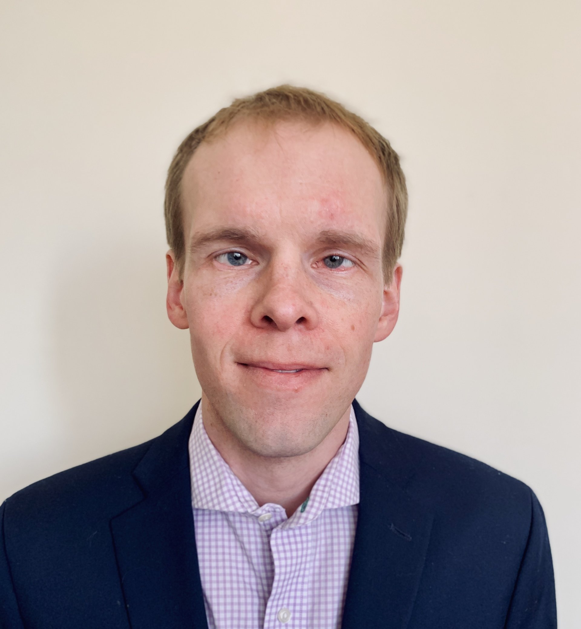 Man with short hair in a suit.